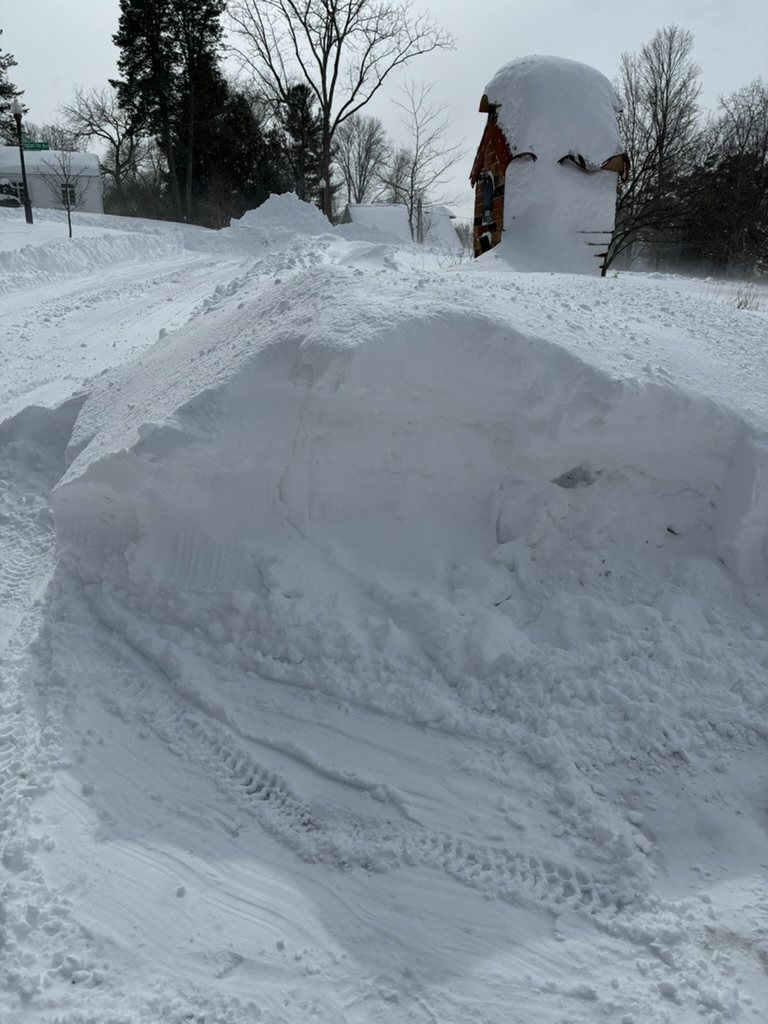 A plow pile burying a mailbox and blocking mail delivery